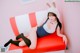 A woman in a bunny costume sitting on a red and white couch.