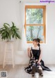 A woman sitting on the floor in front of a window.