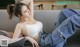 a woman laying on top of a couch next to a pillow